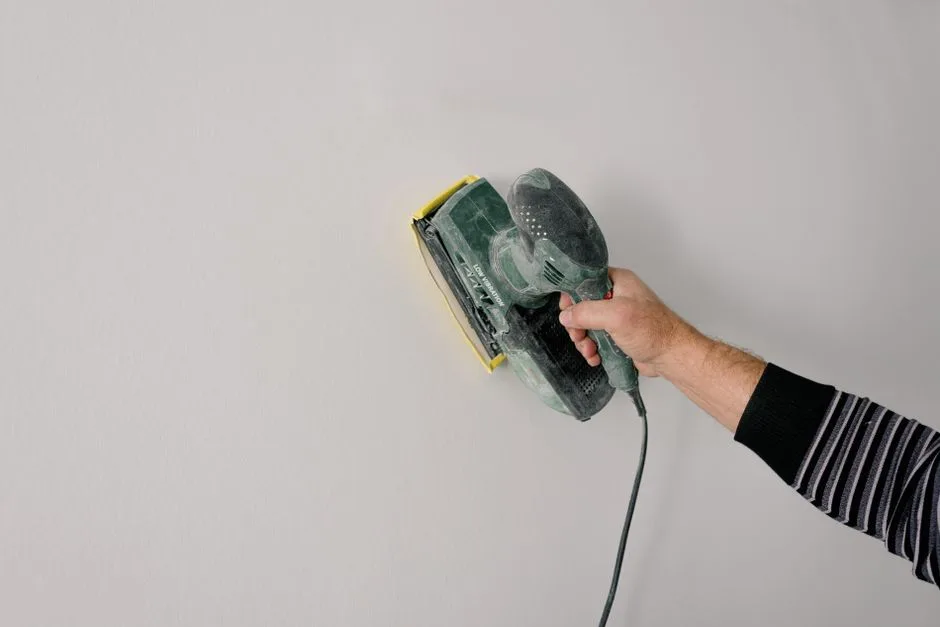 Mur repeint en clair après rebouchage et ponçage, à comparer avec le même mur avant peinture